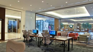 A modern office space with glass walls, multiple workstations, and comfortable seating areas. - Hilton Garden Inn Konya, Turkey (Konya)