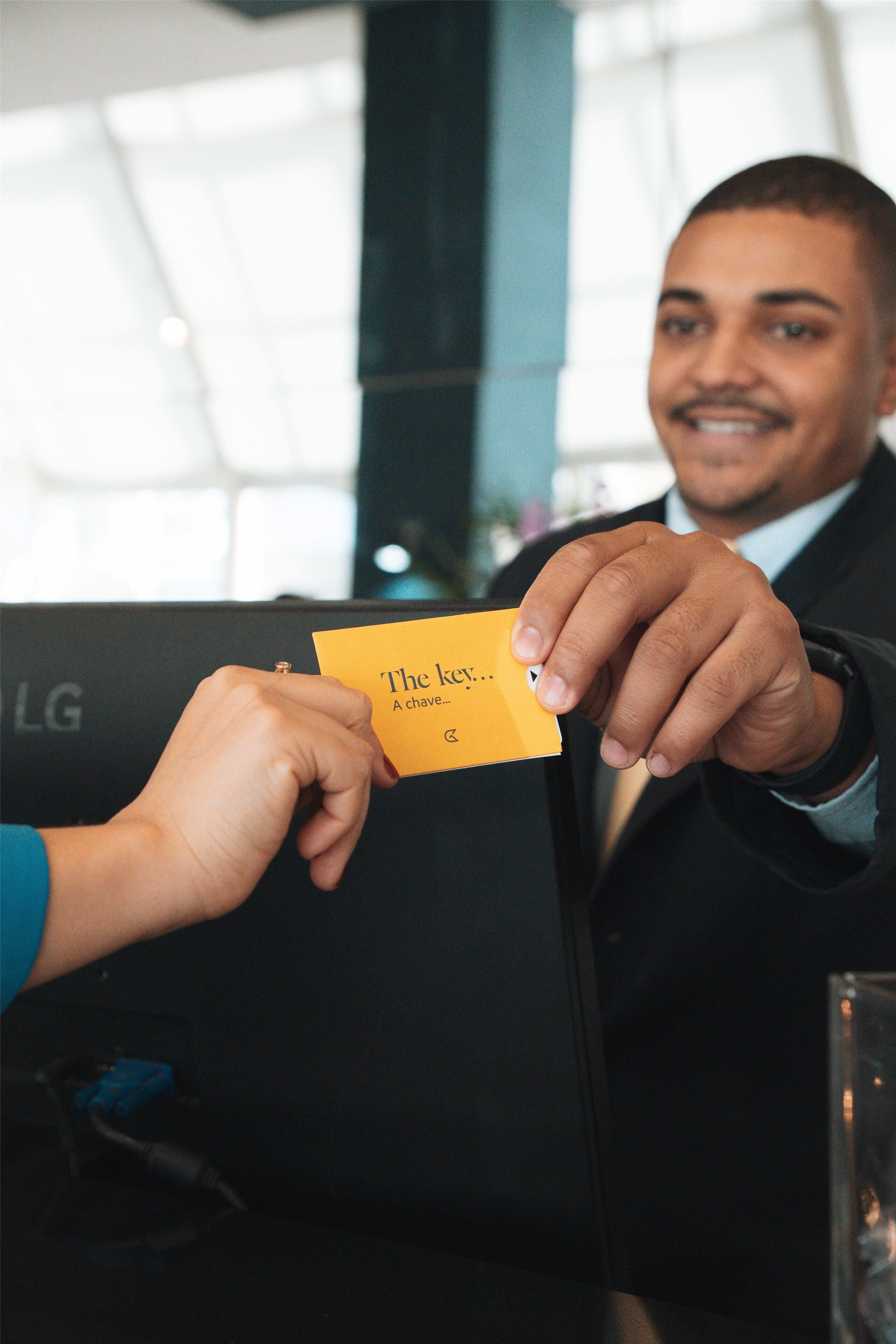 A person handing a yellow card to another person in a formal setting.
