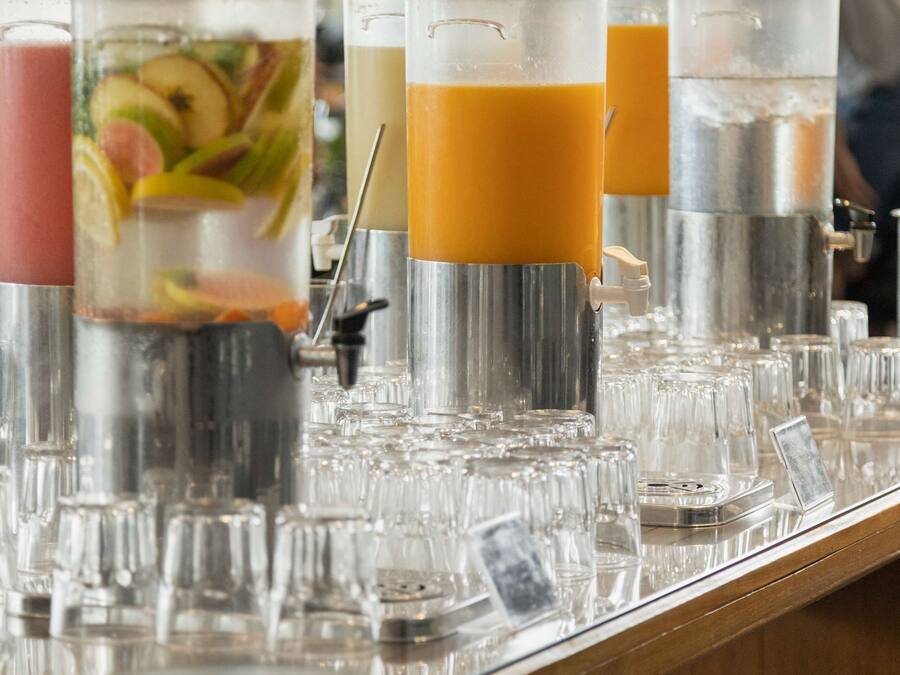 Een bar met meerdere drankdispensers en glazen.