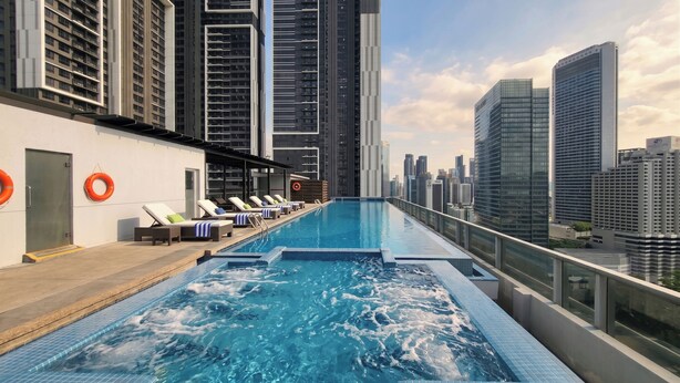 A rooftop pool with lounge chairs and a city skyline view. - Somerset Kuala Lumpur (Kuala Lumpur)
