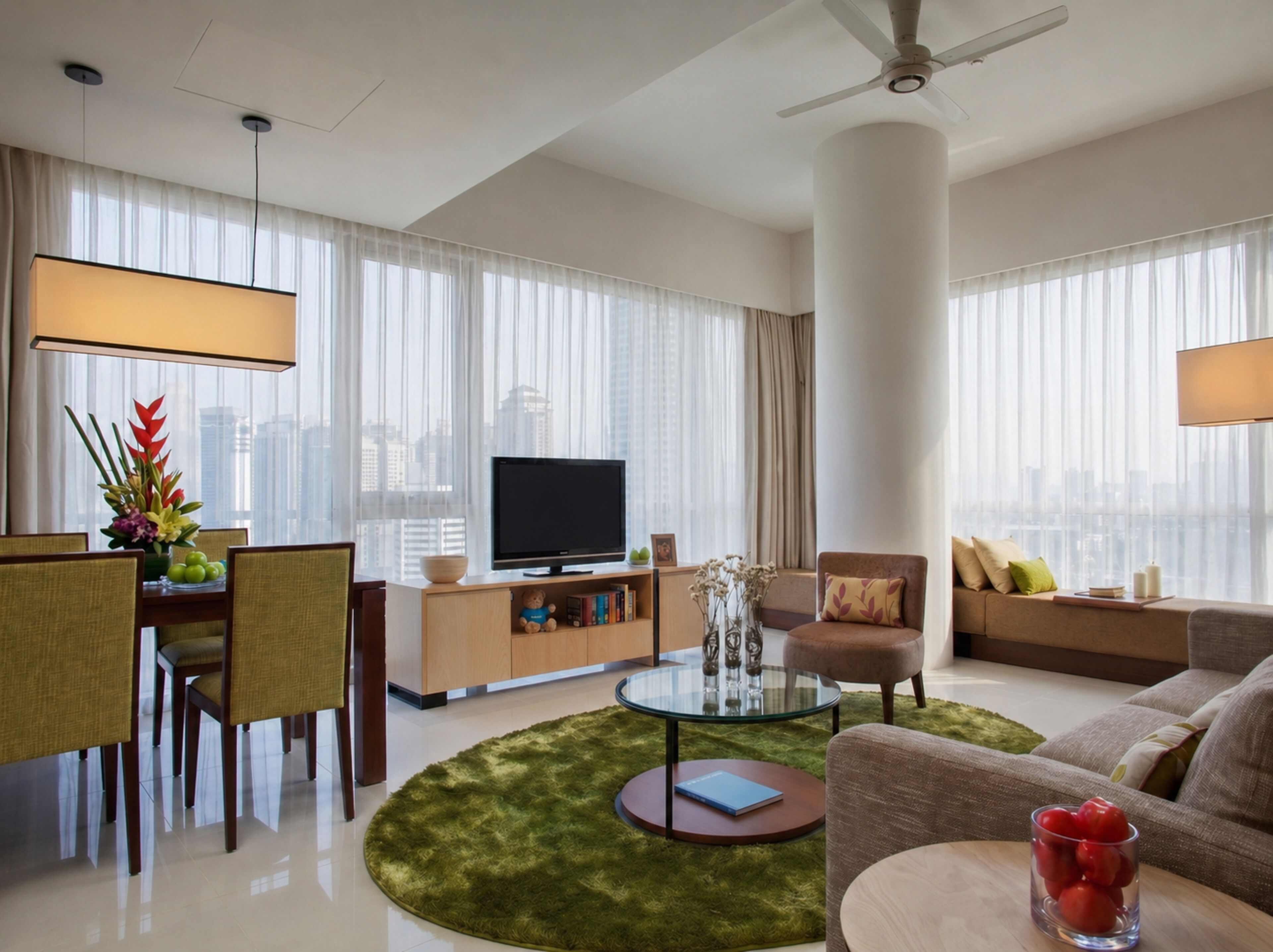 A modern hotel room with a flat-screen TV, a dining area with chairs and a table, a sofa, a coffee table, and a large window with curtains.