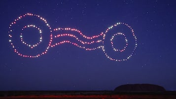 A starry night sky with a large, illuminated structure resembling a bowtie or infinity symbol.