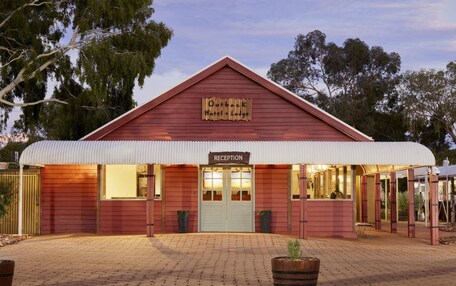 A red building with a sign reading "Outback Hotel & Lodge" and a "Reception" sign.