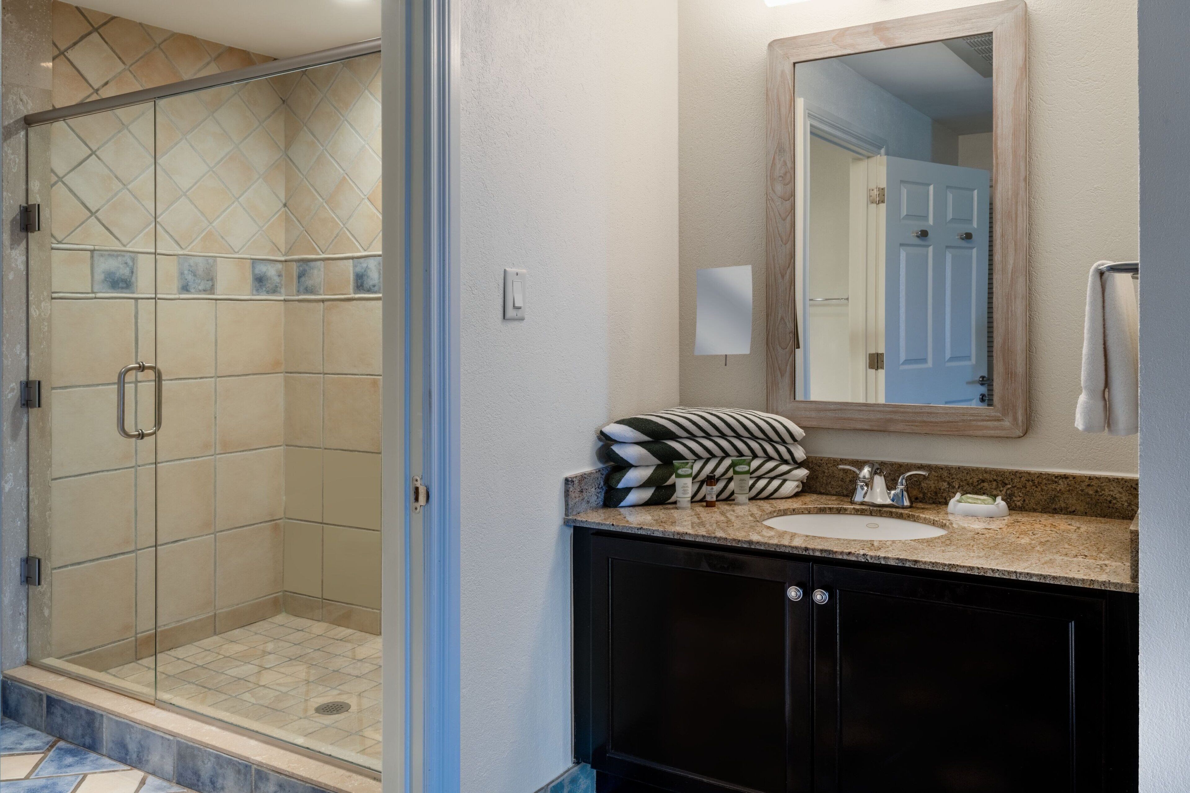 Une salle de bain avec une douche, un lavabo et un miroir.