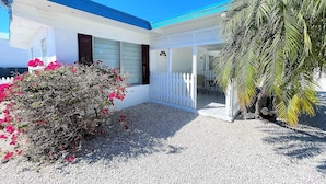 A building with a blue roof and white walls, a gravel driveway, and a white picket fence. - Floating Sea Cove Resort & Marina (Marathon)