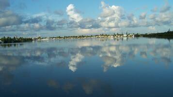 A calm lake with a clear reflection of the sky and clouds.