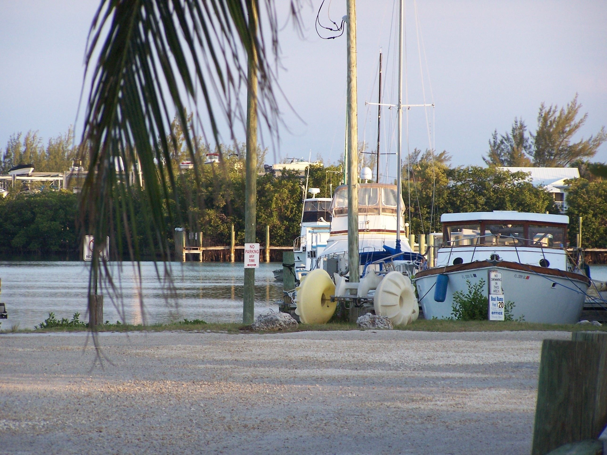 A marina with boats docked, a no parking sign, and a boat named "Blue Lagoon."