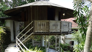 A wooden structure with a balcony, surrounded by greenery and a stone pathway. - Hof Gorei Beach Resort (Samal)