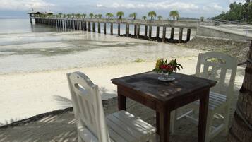 Relax on the beach with a serene view of the ocean from a pier.