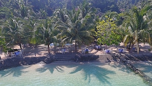 A beachside resort with clear turquoise water, palm trees, and outdoor seating areas. - Hof Gorei Beach Resort (Samal)