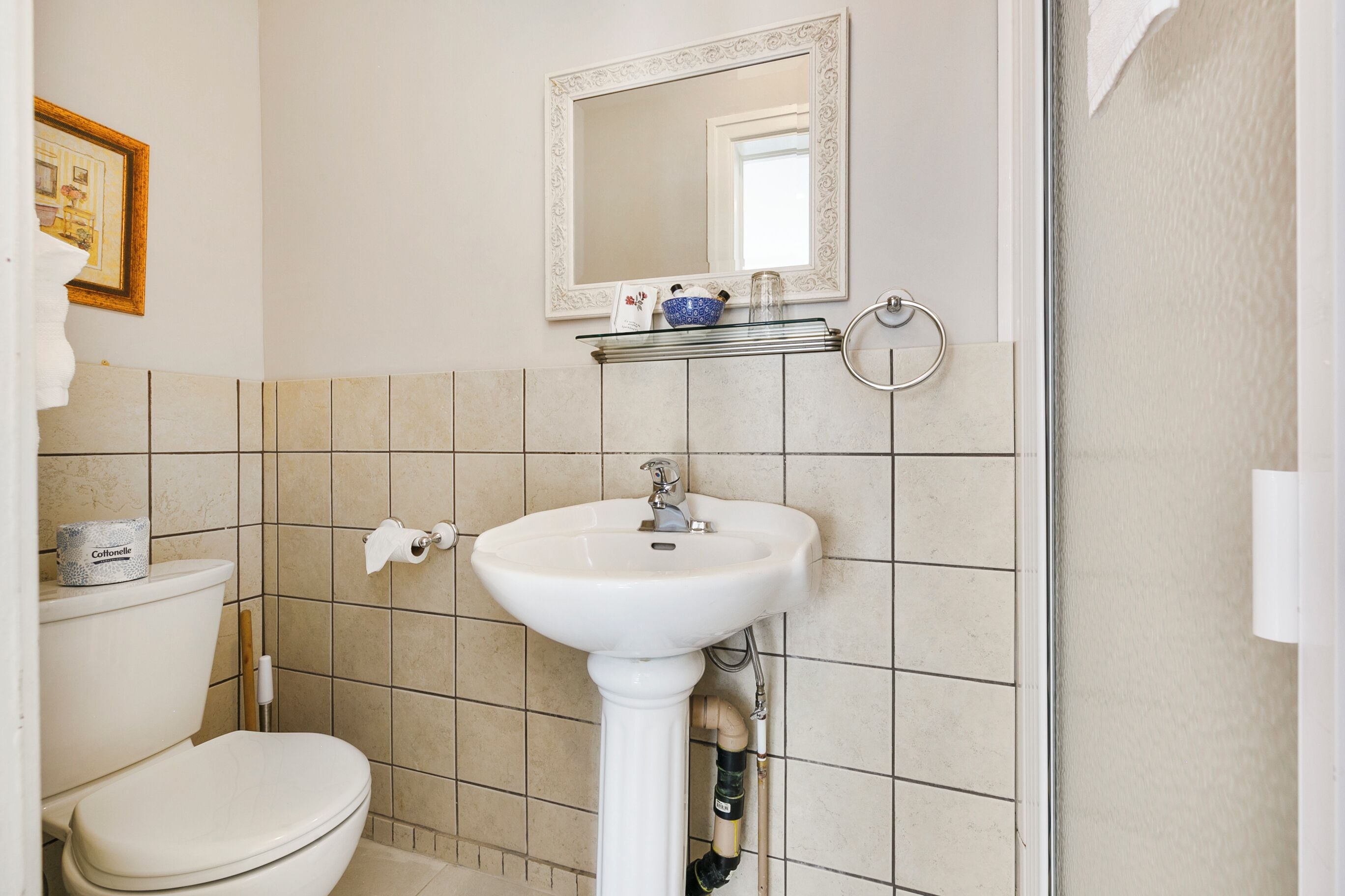 Une salle de bain avec des toilettes, un lavabo et un miroir.