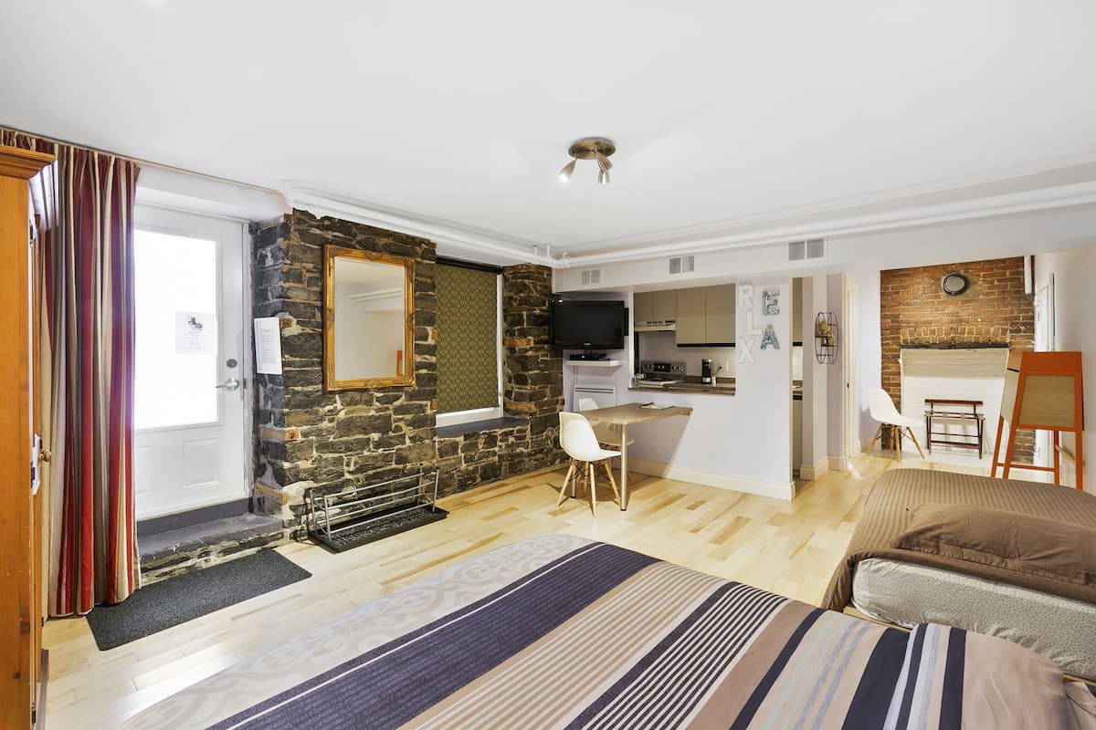 A bedroom with a bed, a desk, and a television.