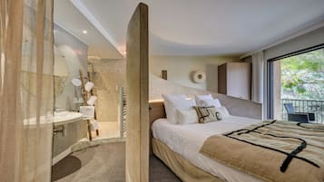 Un dormitorio moderno con una cama grande, un baño con ducha de vidrio y un balcón con vistas.
