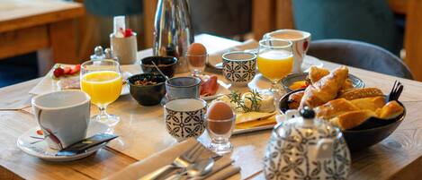 Una mesa de desayuno con diversos alimentos, bebidas y utensilios.