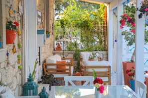 A cozy outdoor seating area with wooden furniture and potted plants.