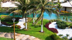 A resort with a pool, palm trees, and a view of the ocean. - Dom Pedro Laguna Beach Resort & Golf by WAM Experience (Aquiraz)