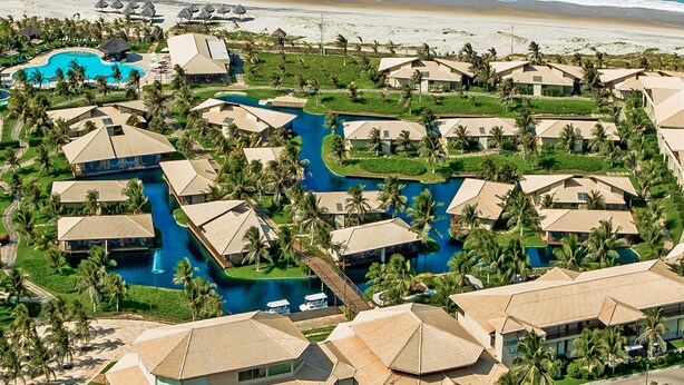 A resort with multiple bungalow-style buildings, a central swimming pool, and a beach view. - Dom Pedro Laguna Beach Resort & Golf by WAM Experience (Aquiraz)
