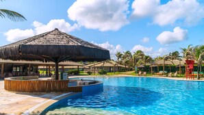 A swimming pool with a thatched umbrella, lounge chairs, and palm trees. - Dom Pedro Laguna Beach Resort & Golf by WAM Experience (Aquiraz)