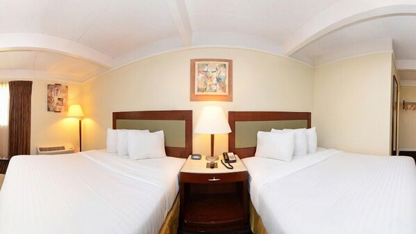 A hotel room with two beds, a nightstand with a lamp, a phone, and a painting on the wall. - Lexington Inn & Suites NW Chicago Elgin (Elgin)