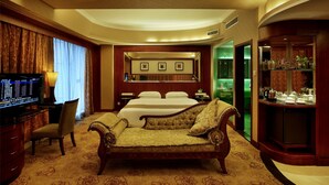 A hotel room with a large bed, a desk with a computer, a chair, and a cabinet with decorative items. - Hongfeng Hotel Shenzhen (Shenzhen)