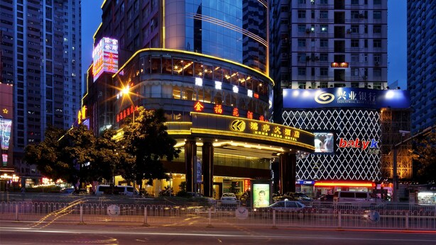 A modern hotel with a curved facade, large windows, and a prominent entrance with a neon sign. - Hongfeng Hotel Shenzhen (Shenzhen)