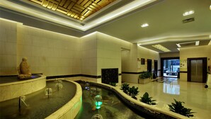 A modern lobby with a central water feature, a reception desk, and a reception area. - Hongfeng Hotel Shenzhen (Shenzhen)