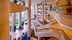 A multi-level atrium with marble columns, glass railings, and indoor plants. - Ningbo Nanyuan Universe Deluxe Hotel (Ningbo)