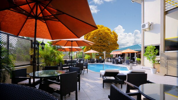 Een terras buiten met tafels, stoelen en parasols.