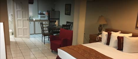 Une chambre d’hôtel avec un lit, un bureau et une chaise.