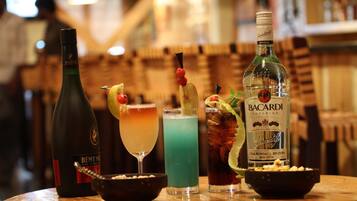 Un bar con una botella de Rémy Martin, Bacardí Superior y tres cócteles.