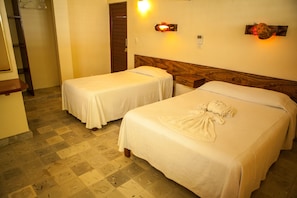 A hotel room with two single beds, a wooden headboard, a small desk, and a mirror. - Hotel Laguna Bacalar (Bacalar)