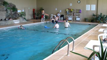Una piscina techada, sillones reclinables de piscina