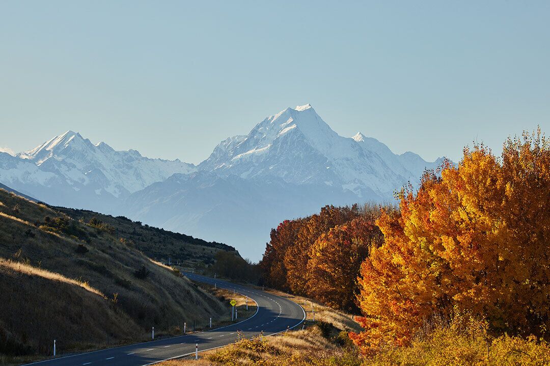 A winding road with a mountain range in the background.