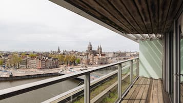 Un balcón con vistas a un paisaje urbano, que incluye edificios históricos y un río.
