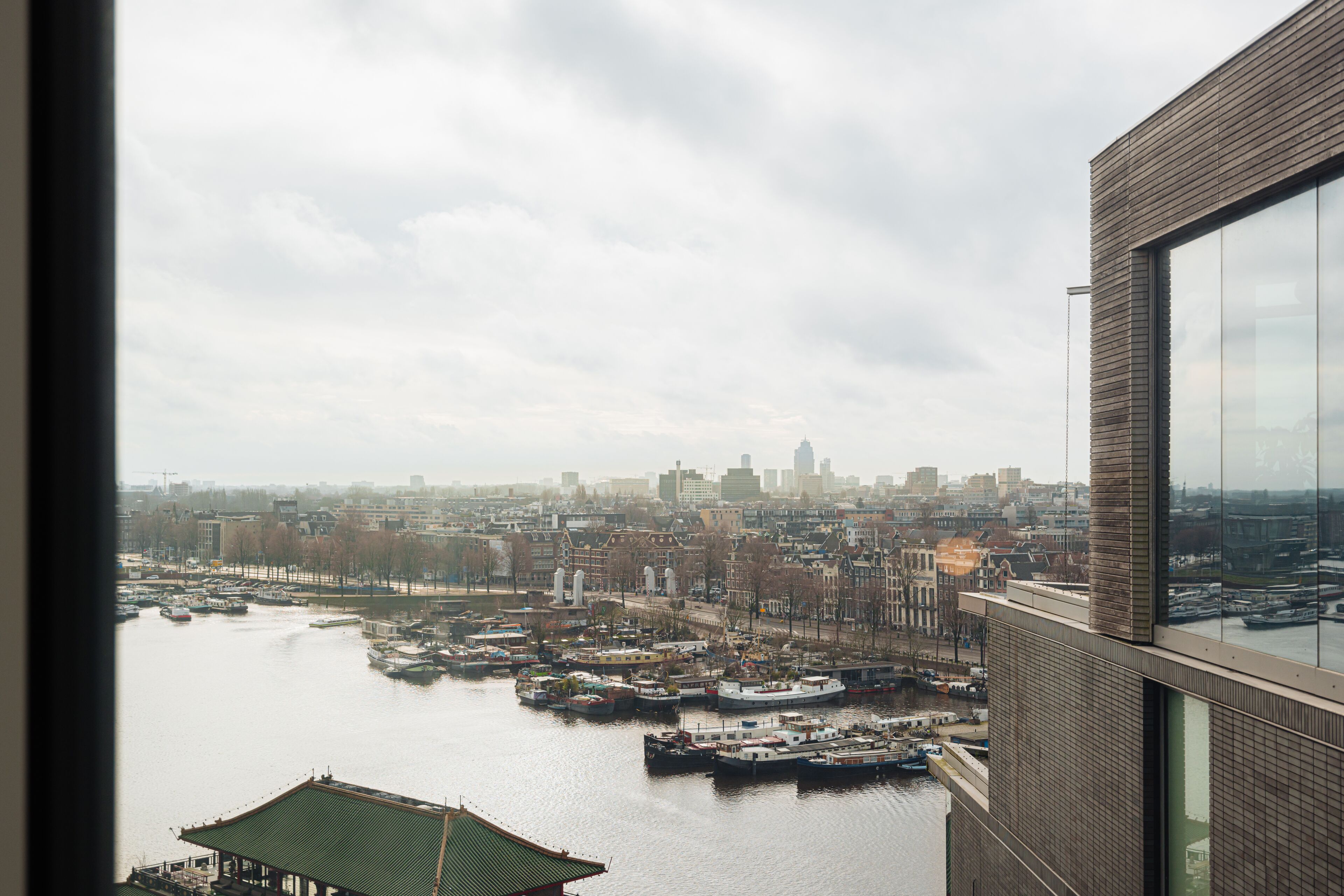 A view of a cityscape with a river, boats, and buildings.