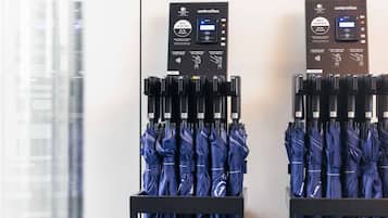 Two umbrella charging stations with multiple blue umbrellas on display.