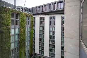 A multi-story building with a mix of glass and metal facade, large windows, and a section with vertical greenery. - DoubleTree by Hilton Hotel London -Tower of London (London)