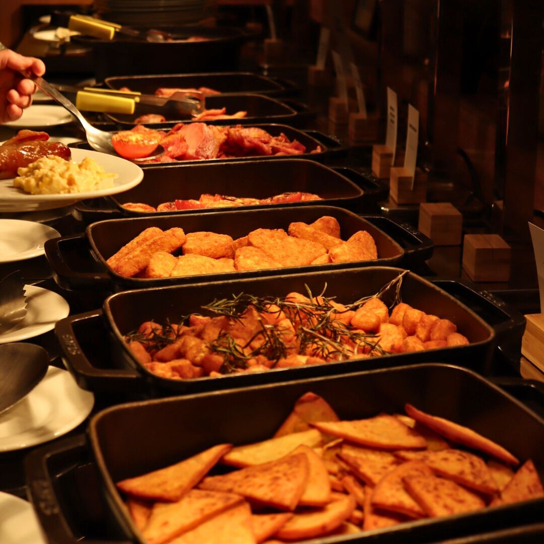 Een buffet met diverse soorten eten, zoals brood, vlees en groenten.