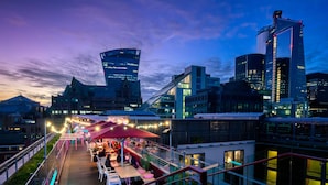 A rooftop bar with outdoor seating and a view of modern buildings. - DoubleTree by Hilton Hotel London -Tower of London (London)