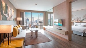 A modern hotel room with a city view, a sofa, a dining table, and a TV. - Sivatel Bangkok (Bangkok)
