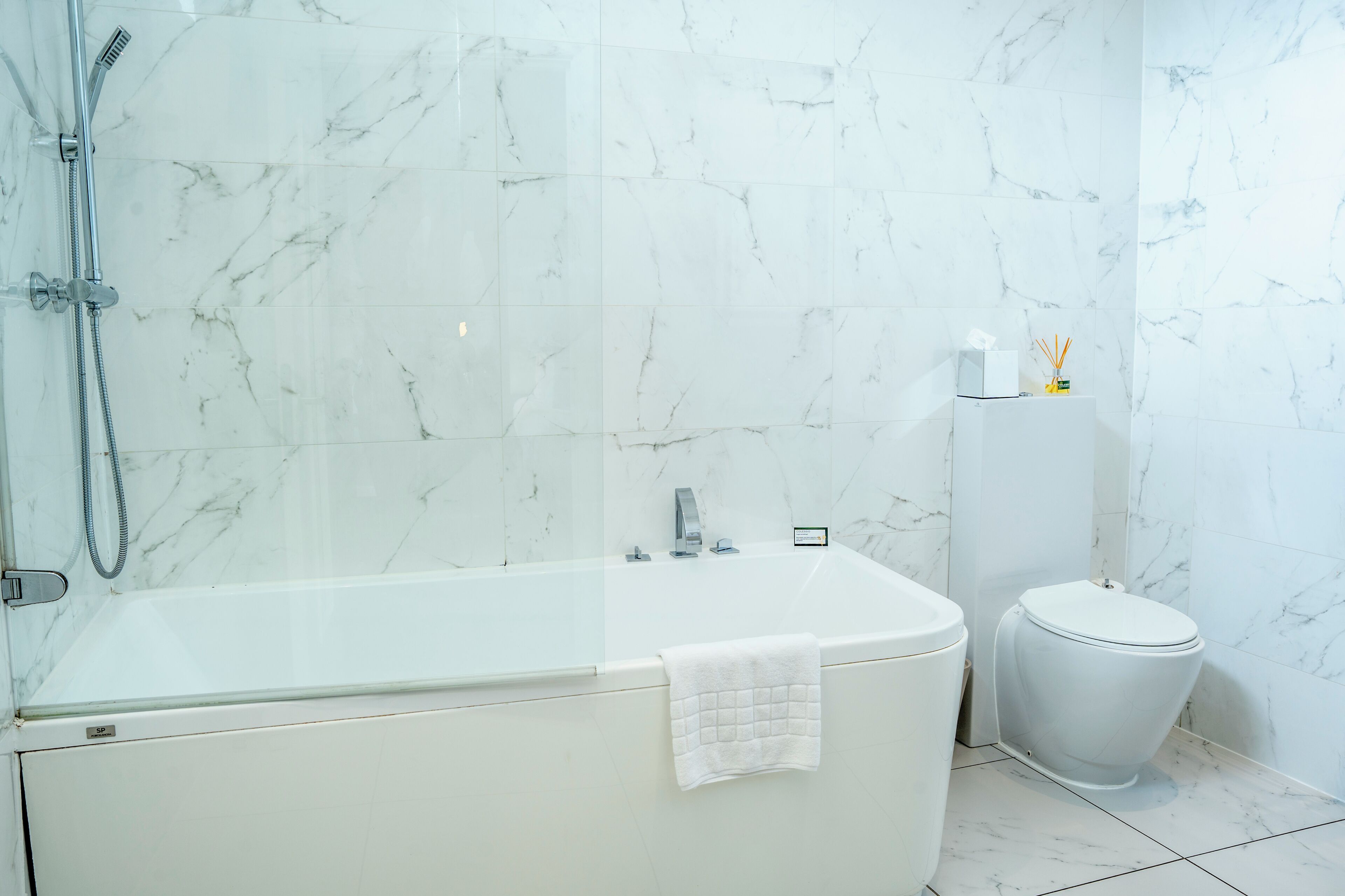 A modern bathroom with a freestanding bathtub, a toilet, and a glass-enclosed shower area.