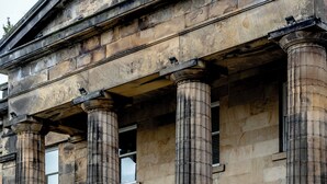 A historic building with large stone columns, a grand entrance, and steps leading up to the door. - Colessio (Stirling)