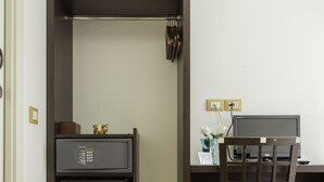 A compact room with a built-in desk, a small refrigerator, and a chair. - L'Affittacamere di Venezia (Mestre)