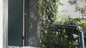 A green door with a metal handrail and a doormat on a concrete step. - L'Affittacamere di Venezia (Mestre)