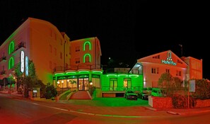 Hotel Fin features a striking entrance with illuminated signs and large windows.