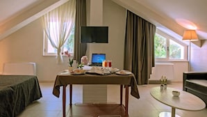 A room with a bed, a table with breakfast items, a laptop, and a TV. - Hotel Fini (San Giovanni Rotondo)