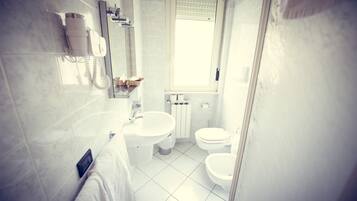 Un baño con lavamanos, inodoro y bidé.