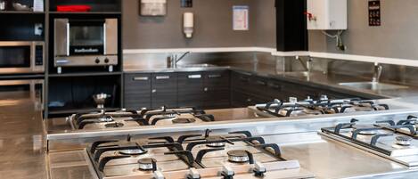 A kitchen with stainless steel appliances, including a stove and microwave, and a sink.
