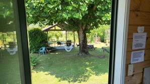 A view of a covered outdoor seating area with tables and chairs, a hammock, and a wooden deck. - Off The Beaten Trail Accommodation & Bike Tours (Murchison)