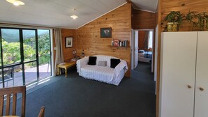 A cozy room with a bed, a desk, and a large window. - Off The Beaten Trail Accommodation & Bike Tours (Murchison)